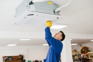 فني تركيب مكيفات سبليت بالرياض يقوم بفك وحدة كونسيلد من السقف